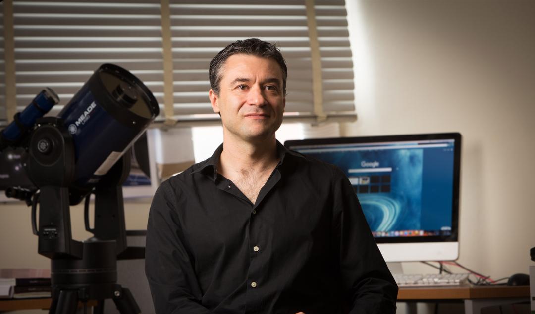 Davide Lazzati sitting in office.