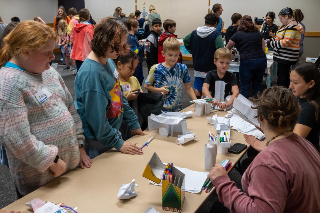 Students gather around a table.