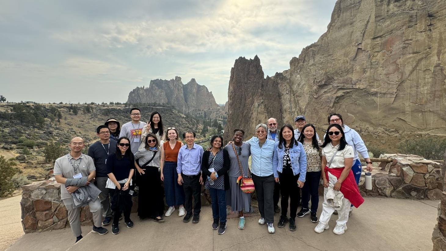 A group of people standing in front of a rocky backdrop of canyons