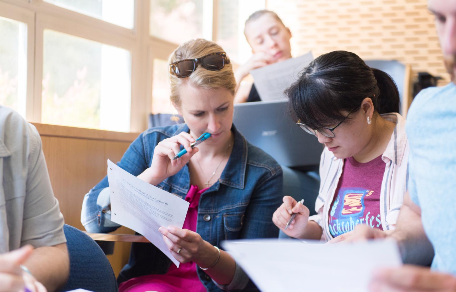 Two women students work together in a sunny statistics classroom