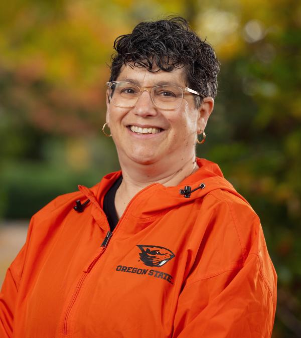 Headshot of Eleanor Feingold smiling on campus, wearing a bright beavs jacket